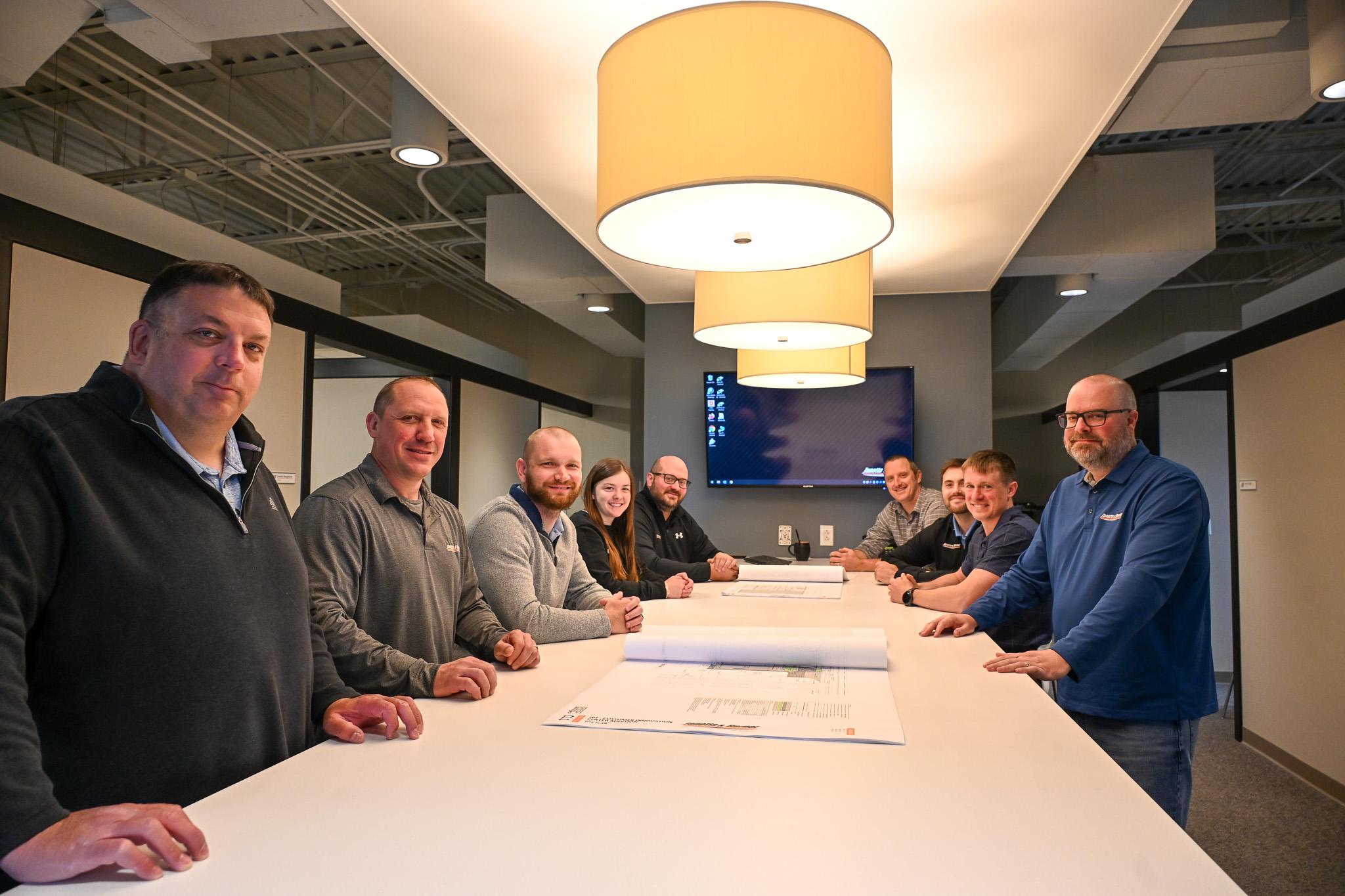 various janotta & herner employees gathered around a meeting table